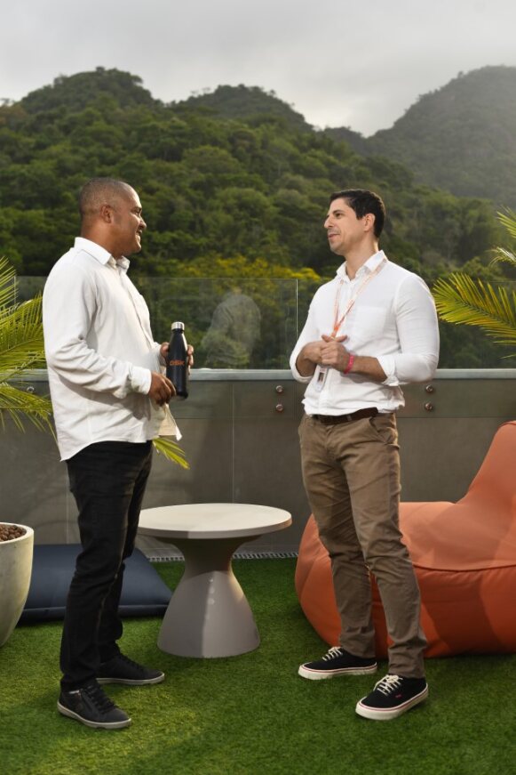 Duas pessoas conversando sobre responsabilidade ambiental com um fundo de natureza preservada