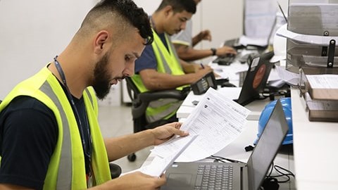 Funcionário administrativo analisando notas fiscais