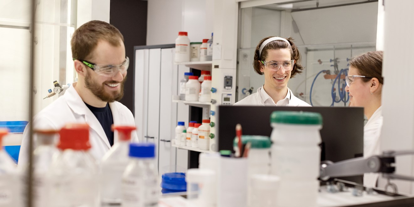 cientistas em laboratório sorrindo.