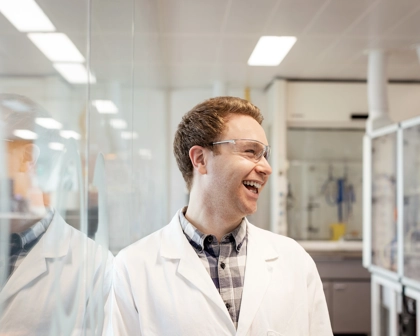 Homem em uma laboratório, sorrindo. GSK